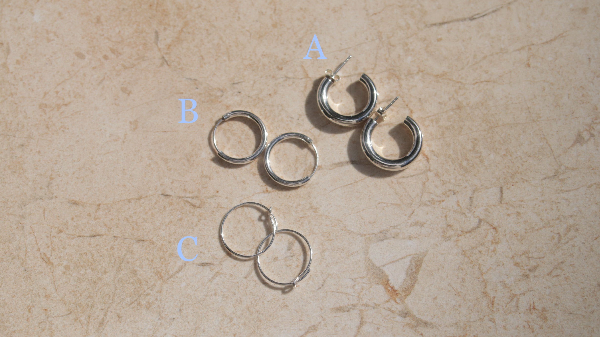 This image shows some of our silver hoops. Hoop A is a stylish pair of silver hoop earrings . These polished hinged hoops have a thick tubular body