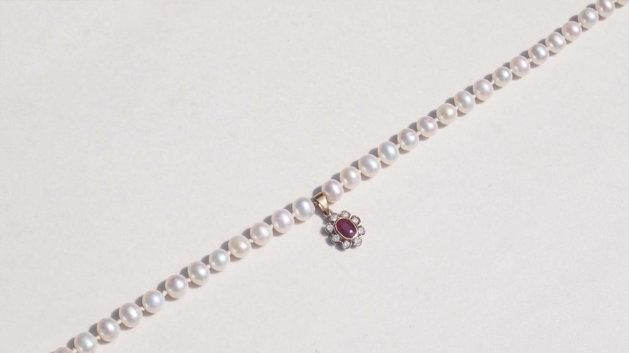 A luxury single strand freshwater pearl necklace decorated with 14ct yellow gold ruby flower pendant. This necklace is made from 62 freshwater pearls, each rich in colour with a lustrous surface.