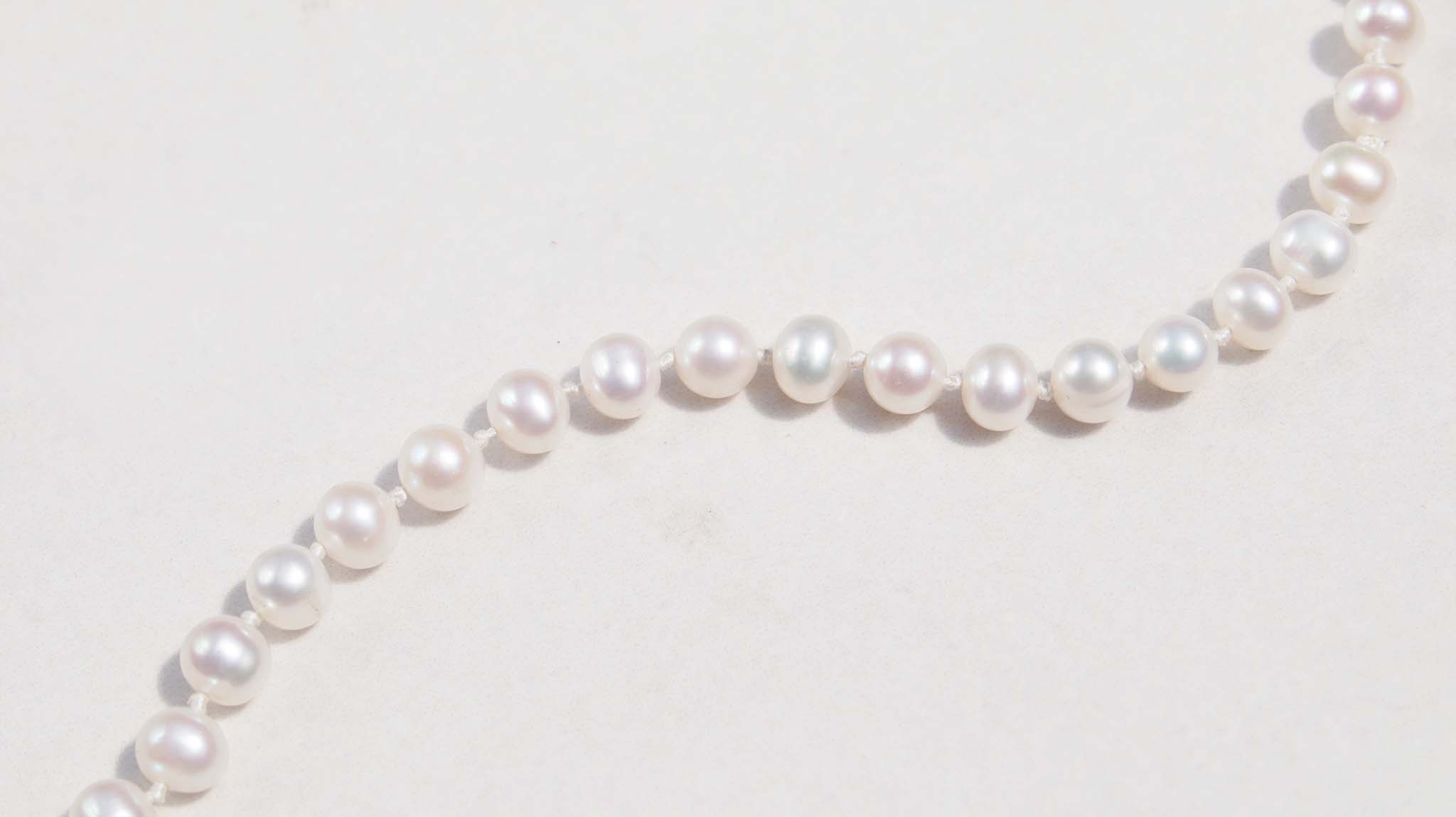 A luxury single strand freshwater pearl necklace decorated with 14ct yellow gold ruby flower pendant. This necklace is made from 62 freshwater pearls, each rich in colour with a lustrous surface.