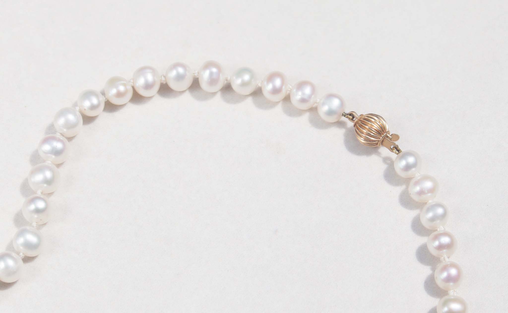 A luxury single strand freshwater pearl necklace decorated with 14ct yellow gold ruby flower pendant. This necklace is made from 62 freshwater pearls, each rich in colour with a lustrous surface.