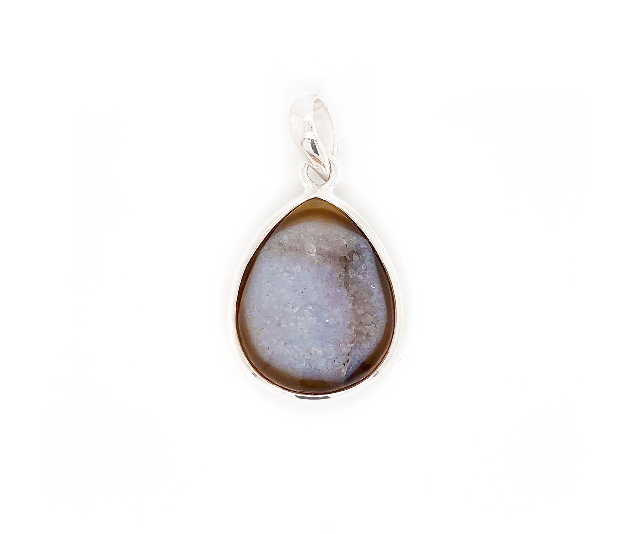 This sterling silver pendant features a Onyx, a variety of chalcedony and a member of the quartz family with a hexagonal crystal system. This gem stands out among others, due to the lustrous colony of crystals formed on its surface known as druzy. This special brown onyx has an visible band across on the top with a unique surface of crystals.