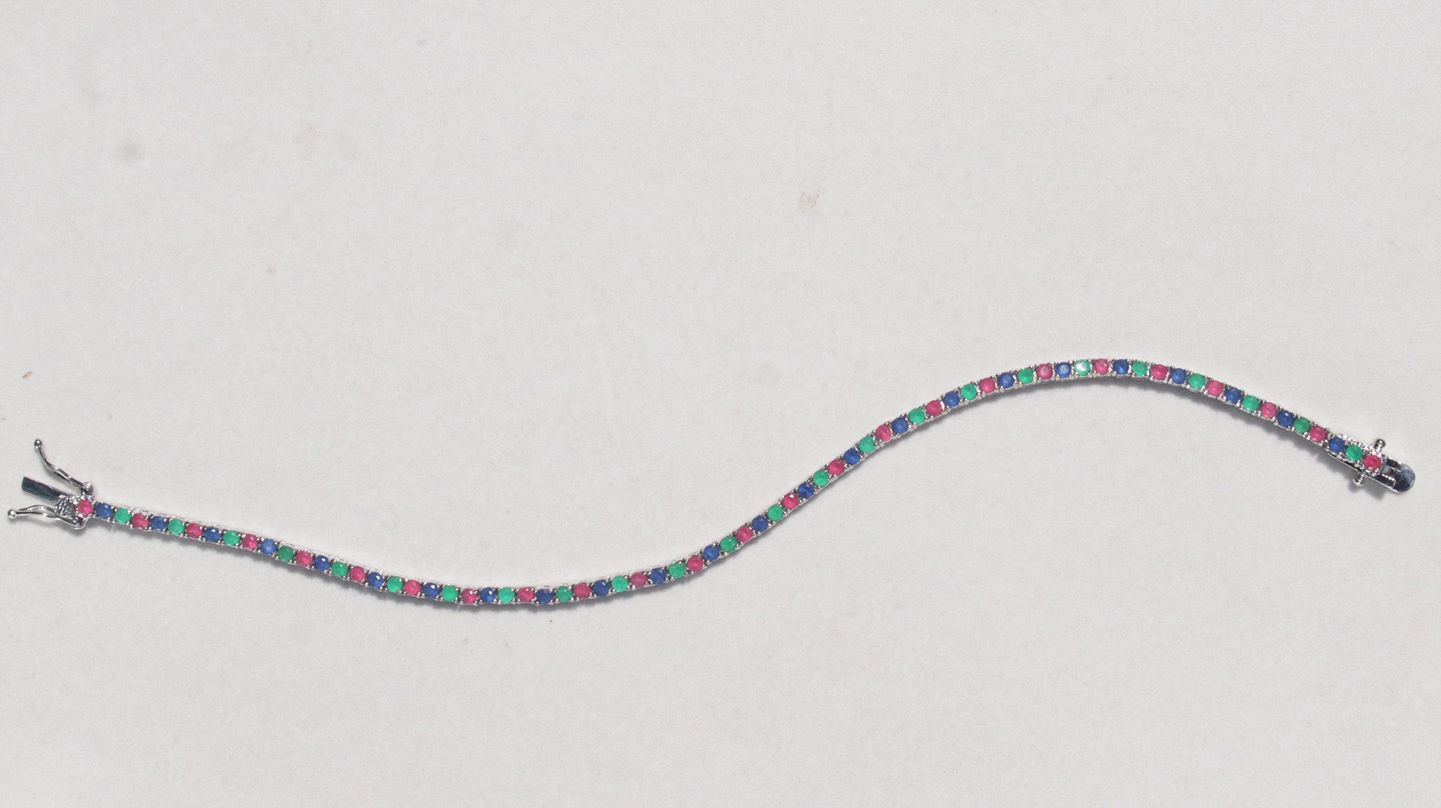 This sterling silver bracelet features a classic arrangement of claw set ruby, emerald and sapphire.This bracelet measures 7.4 inches, with a tongue and groove clasp.