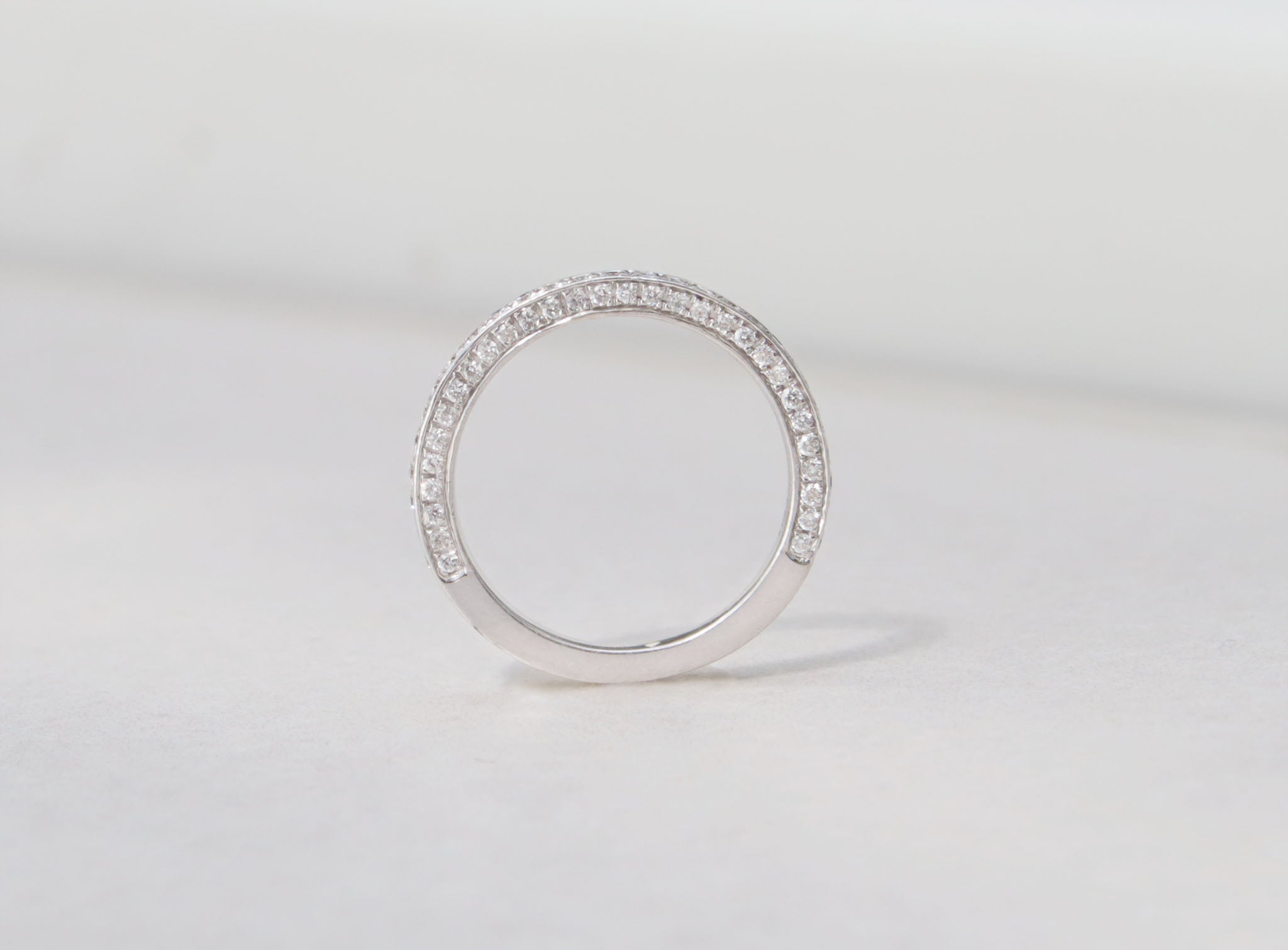 A ladies half eternity ring set in 18kt white gold. This band features round brilliant cut diamonds set on the front and side profiles of the band. Hand made from 18kt white gold Half eternity band Round brilliant cut diamonds, total carat weight 0.90cts SI1, Colour F-G