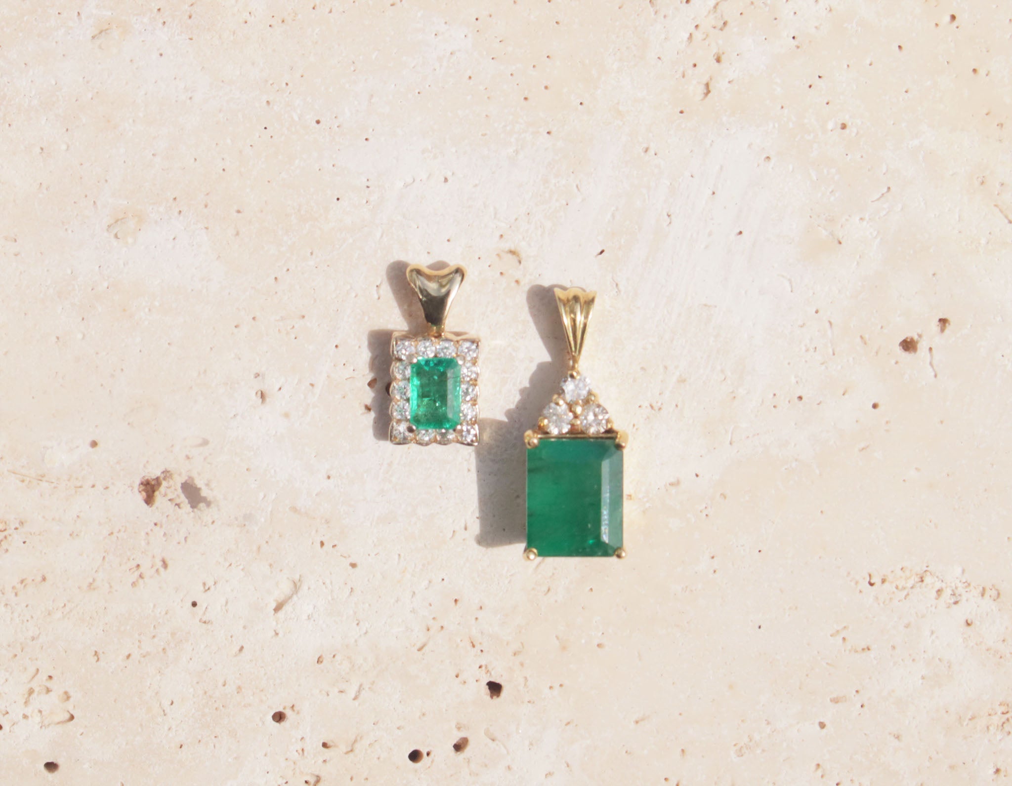 Two 18ct yellow gold emerald and diamond pendants