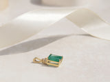 Simple but striking, this yellow gold pendant showcases a three carat Colombian emerald with three round brilliant cut diamonds.   Emerald is the birthstone for May  Emerald celebrates the twentieth and thirty-fifth wedding anniversaries