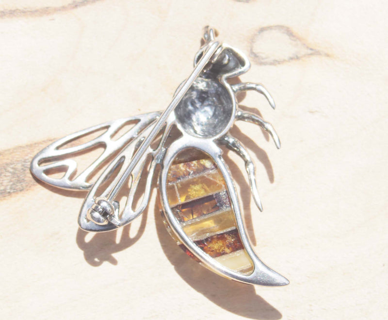 This image shows the back of the brooch. A captivating sterling silver queen bee brooch.   Detailed with texture, this brooch features a beautiful variety of natural amber.  