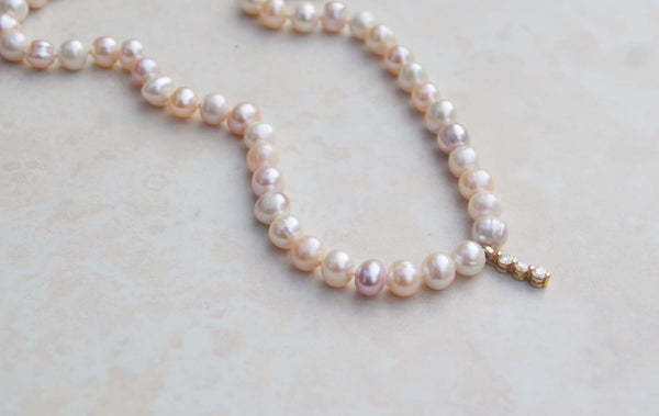 A luxury single strand freshwater pearl necklace decorated with 18kt yellow gold diamond pendant. This necklace is made from 52 freshwater pearls, each rich in colour with a lustrous surface. 