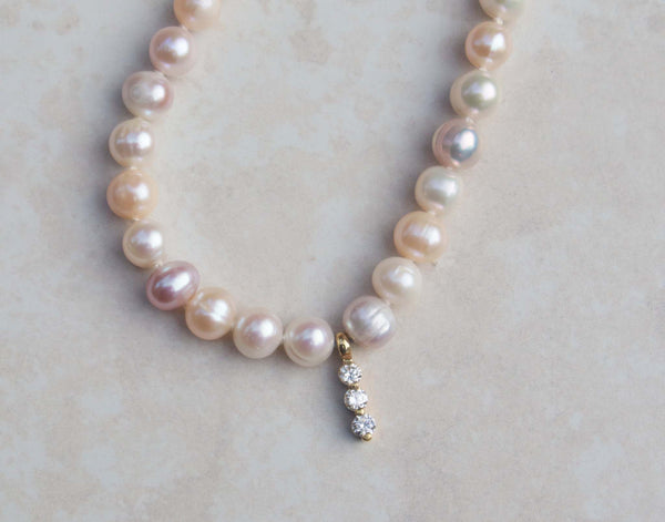 A luxury single strand freshwater pearl necklace decorated with 18kt yellow gold diamond pendant. This necklace is made from 52 freshwater pearls, each rich in colour with a lustrous surface. 