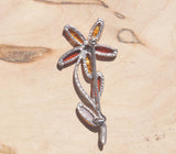 A beautiful sterling silver amber flower brooch.   Each petal displays a variety of honey and cognac natural amber, finished with two cognac leaves. This images shows the back of the brooch.