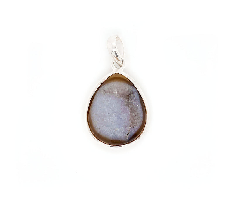 This sterling silver pendant features a Onyx, a variety of chalcedony and a member of the quartz family with a hexagonal crystal system. This gem stands out among others, due to the lustrous colony of crystals formed on its surface known as druzy. This special brown onyx has an visible band across on the top with a unique surface of crystals.    