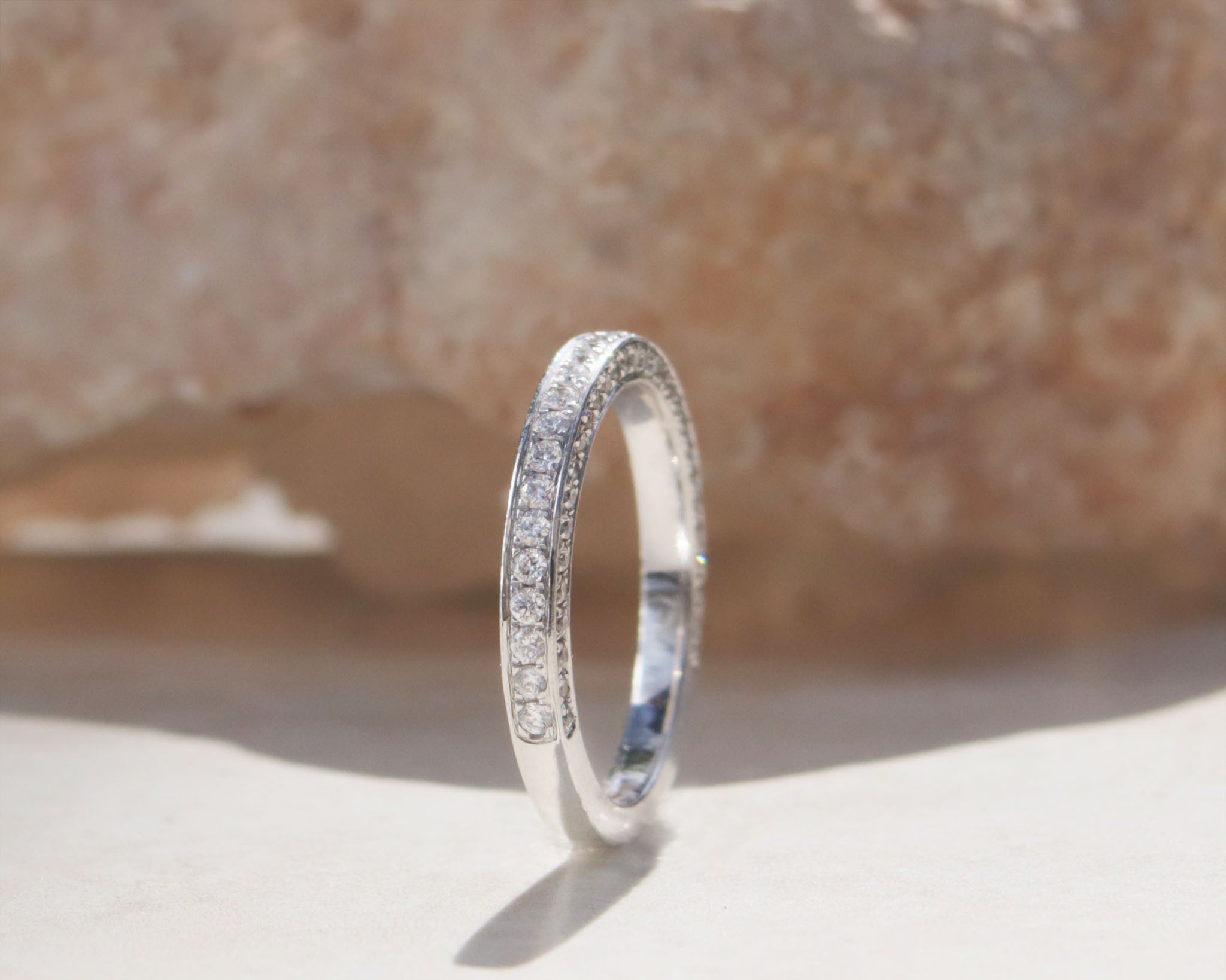 A ladies half eternity ring set in 18kt white gold.  This band features round brilliant cut diamonds set on the front and side profiles of the band.   Hand made from 18kt white gold  Half eternity band Round brilliant cut diamonds, total carat weight 0.90cts SI1, Colour F-G