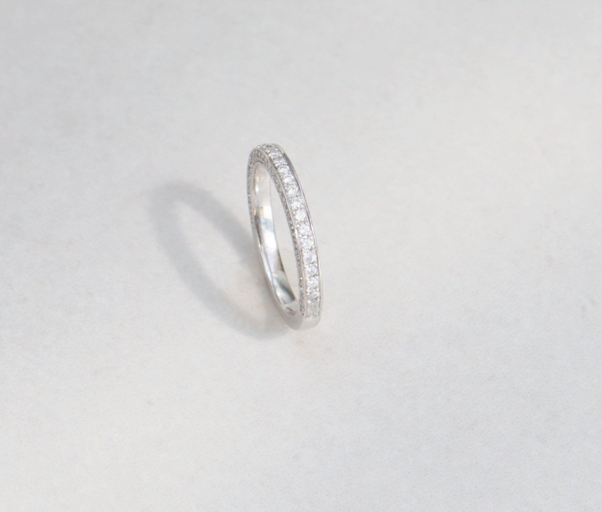 A ladies half eternity ring set in 18kt white gold.  This band features round brilliant cut diamonds set on the front and side profiles of the band.   Hand made from 18kt white gold  Half eternity band Round brilliant cut diamonds, total carat weight 0.90cts SI1, Colour F-G