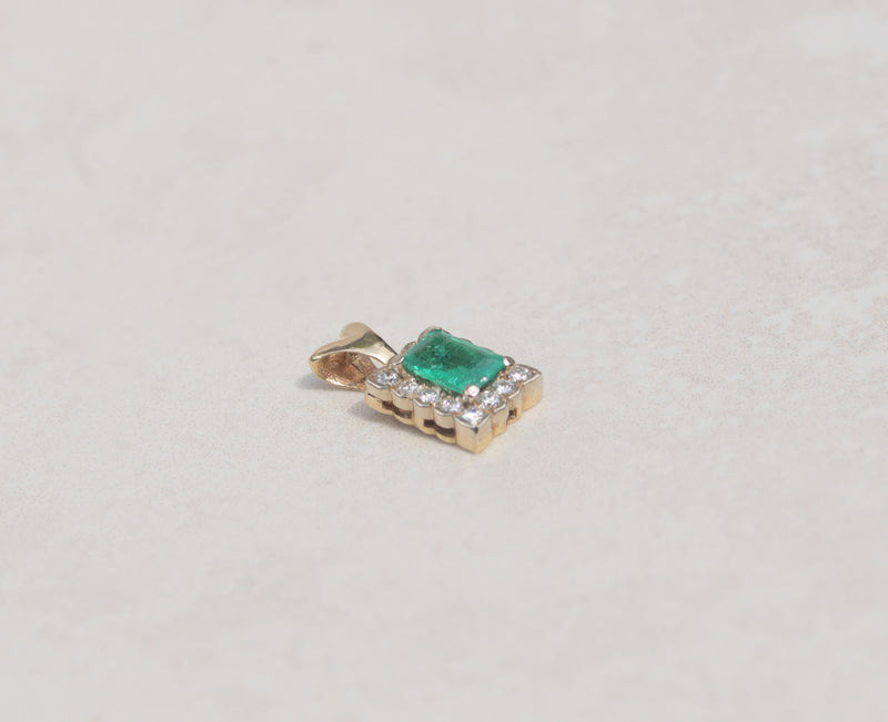 This gorgeous pendant features an emerald gemstone with a diamond halo. Held by slim prongs, the green emerald measures 0.50cts and takes centre stage among rows of round brilliant cut diamonds.  Emerald is the birthstone for May  Emerald celebrates the twentieth and thirty-fifth wedding anniversaries