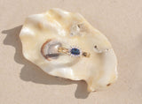 This classic design features a royal blue sapphire surrounded by a cluster of diamonds set in 9kt yellow gold band. The outer claw setting creates an elegant Edwardian aesthetic and makes this ring a real sparkling showstopper. 